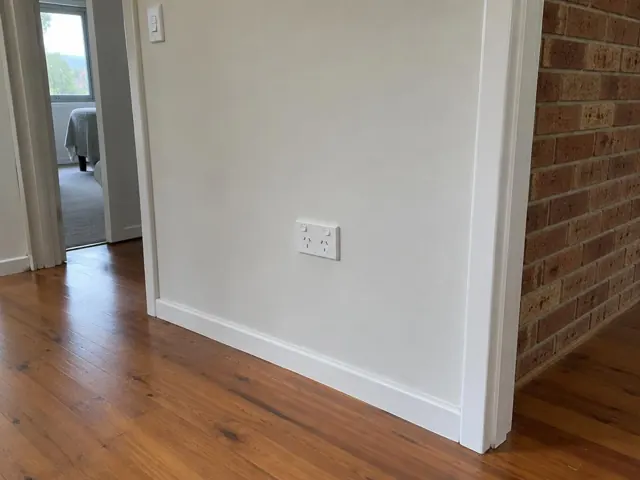 White double power point on a painted hallway wall with timber floor and brick feature wall in Terrigal